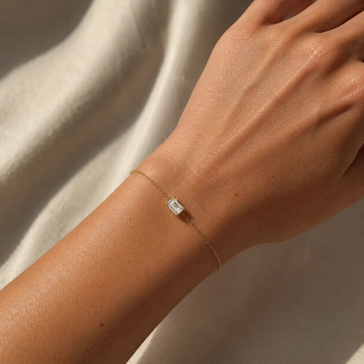 Bracelet Éclat Émeraude en or jaune 18 carats avec diamant taille émeraude porté au poignet