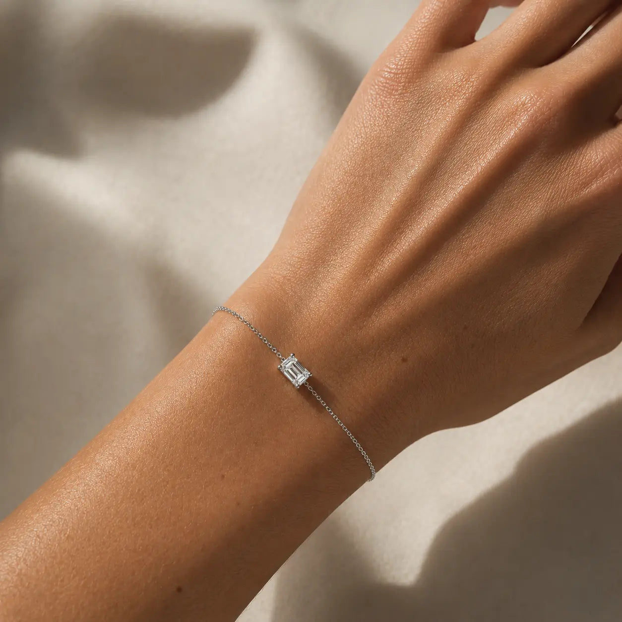 Bracelet Éclat Émeraude en or blanc 18 carats avec diamant taille émeraude porté au poignet