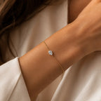 Bracelet LEANNA en or jaune 18 carats avec diamant poire de laboratoire porté au poignet d'une femme en blazer blanc
