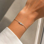 Bracelet Nina en or blanc 18 carats serti d’un diamant marquise et de deux diamants ronds, porté au poignet.