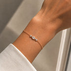 Bracelet Nina en or rose 18 carats serti d’un diamant marquise et de deux diamants ronds, porté au poignet.