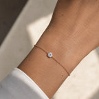 Bracelet SAONA en or rose 18 carats avec diamant rond de laboratoire porté au poignet d'une femme en chemise blanche