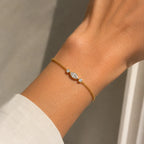 Bracelet Nina en or jaune 18 carats serti d’un diamant marquise et de deux diamants ronds, porté au poignet.